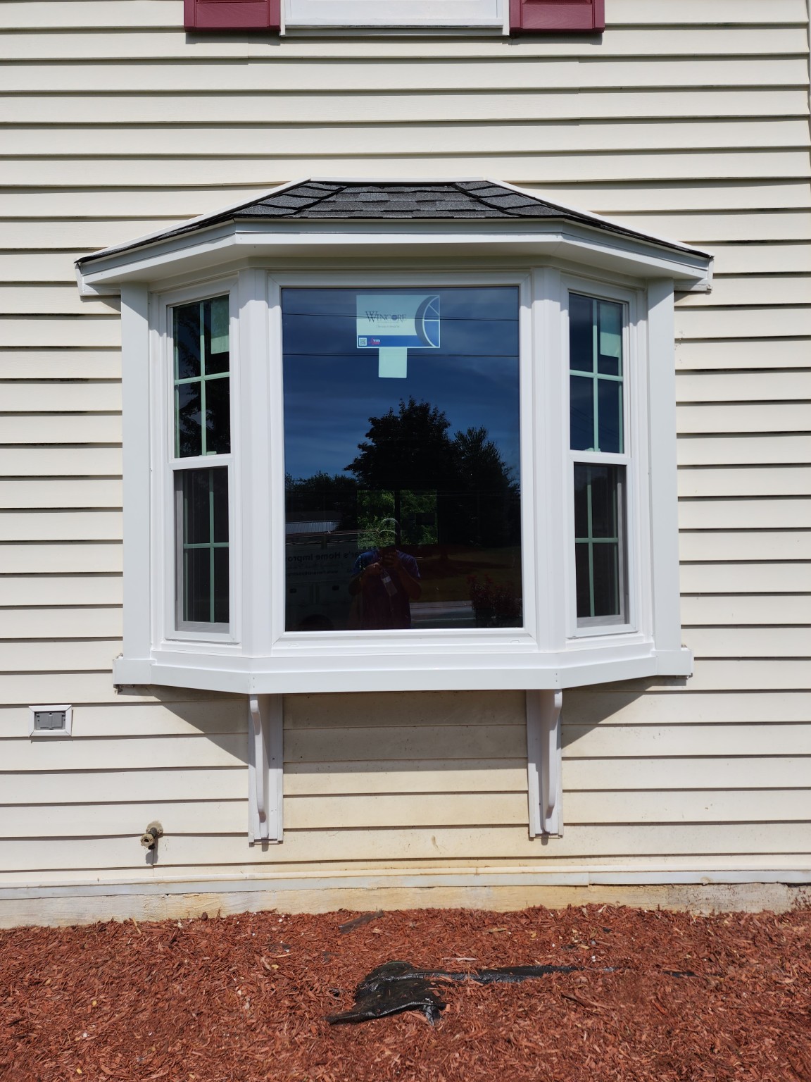 Replacement white bay window with a large center pane and two side windows