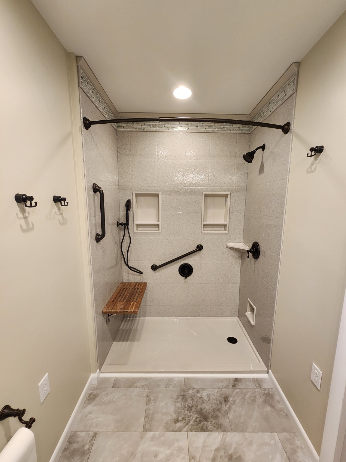 After: walk-in shower with bench, grab bars and new surround