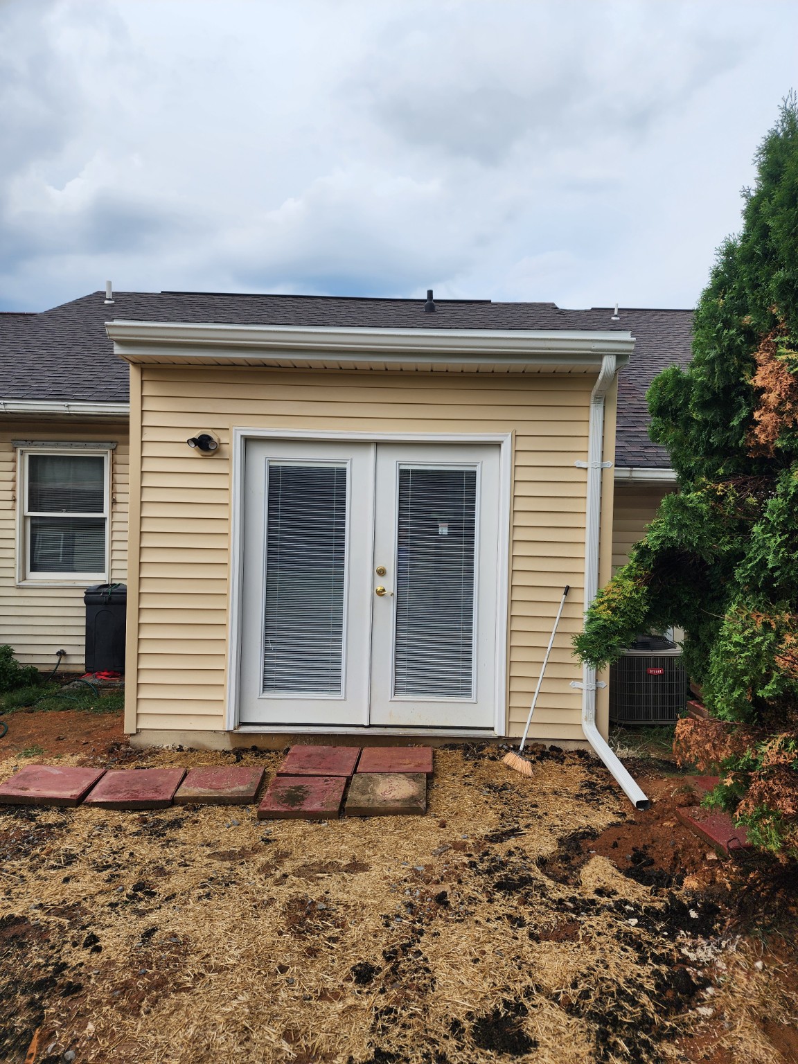 After: expanded sunroom exterior with siding and double doors