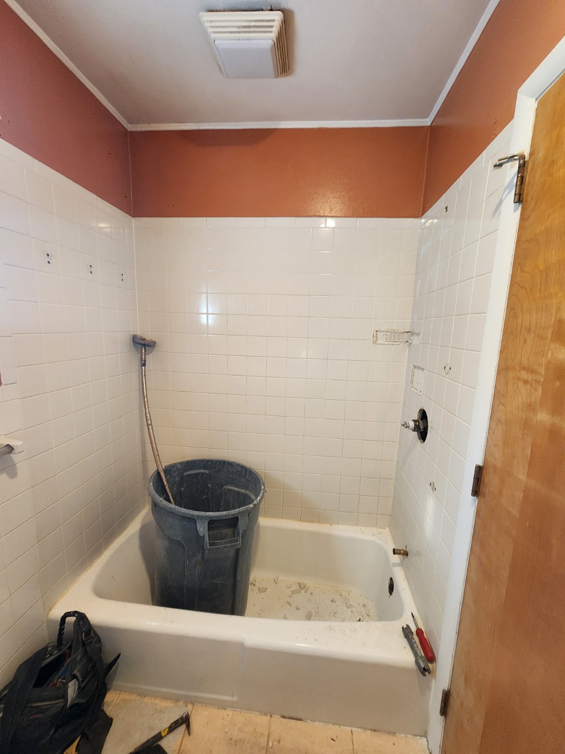 Before: old bathtub and white tiled surround
