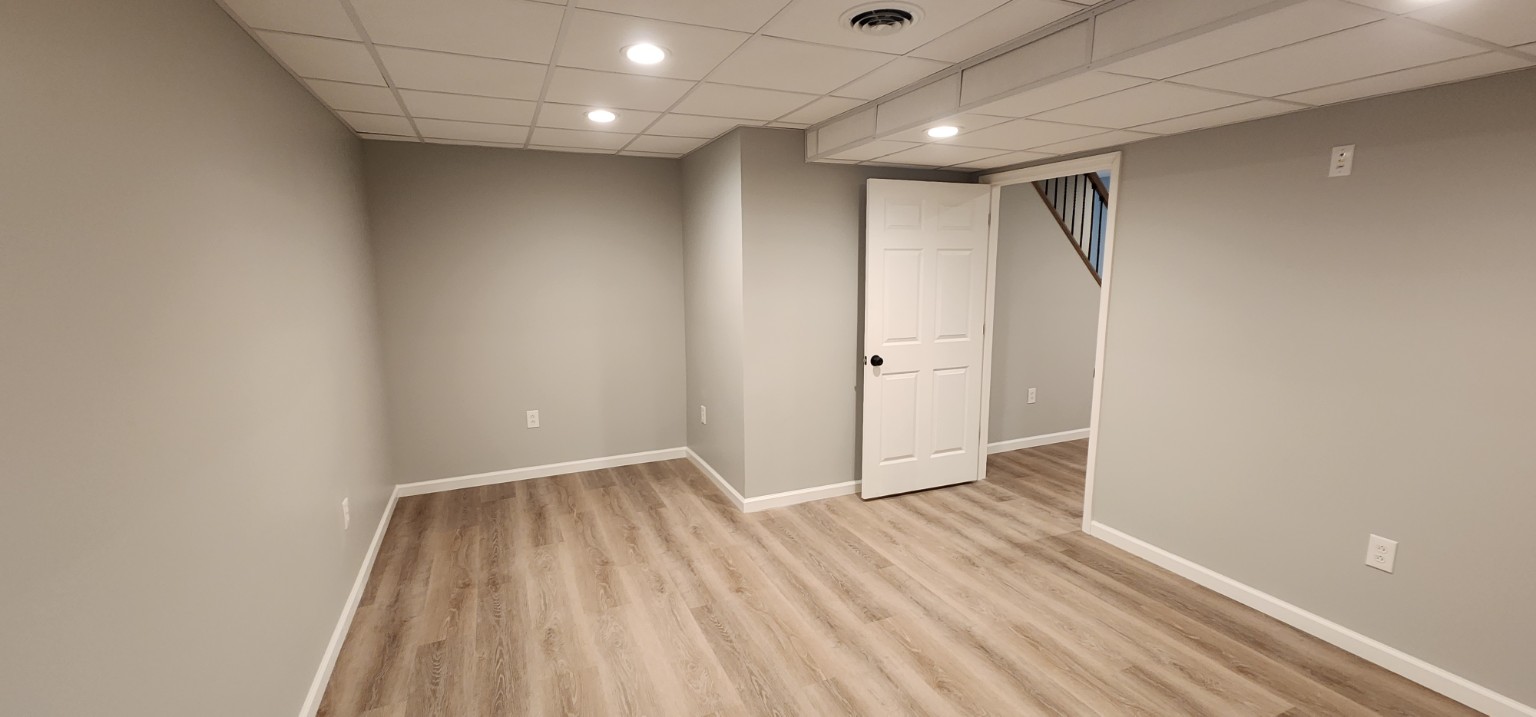 Finished basement room with new flooring and ceiling